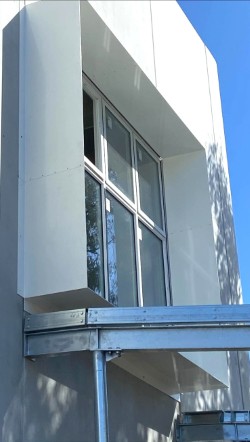 Tall corner aluminium window shroud on multi-storey inner-north Melbourne apartment