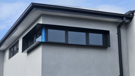 Three matte black aluminium window shrouds on rendered inner-east Melbourne townhouse